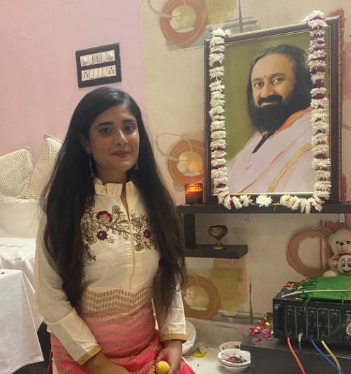Harshil Kalia posing with the picture of her guru