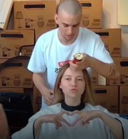 Łatwogang while shaving his friend's head in a still from livestream fundraiser video for charity in April 2026