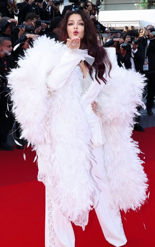 Aishwarya Rai Bachchan wearing Cheney Chan dramatic white couture pantsuit with feather detailing at the closing ceremony of the 2025 Cannes Film Festival