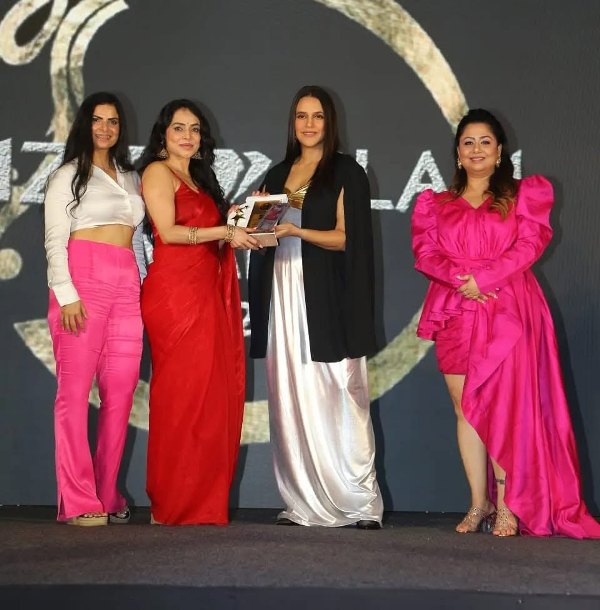 Nikita Rawal receiving the 2022 Bizz Glam Award from actress Neha Dhupia