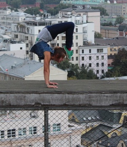 An old picture of Angela Nikolau while practising yoga at the top of a roof